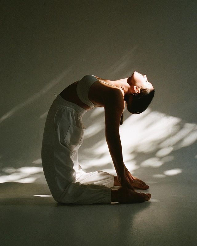 Woman in a yoga backbend in soft light